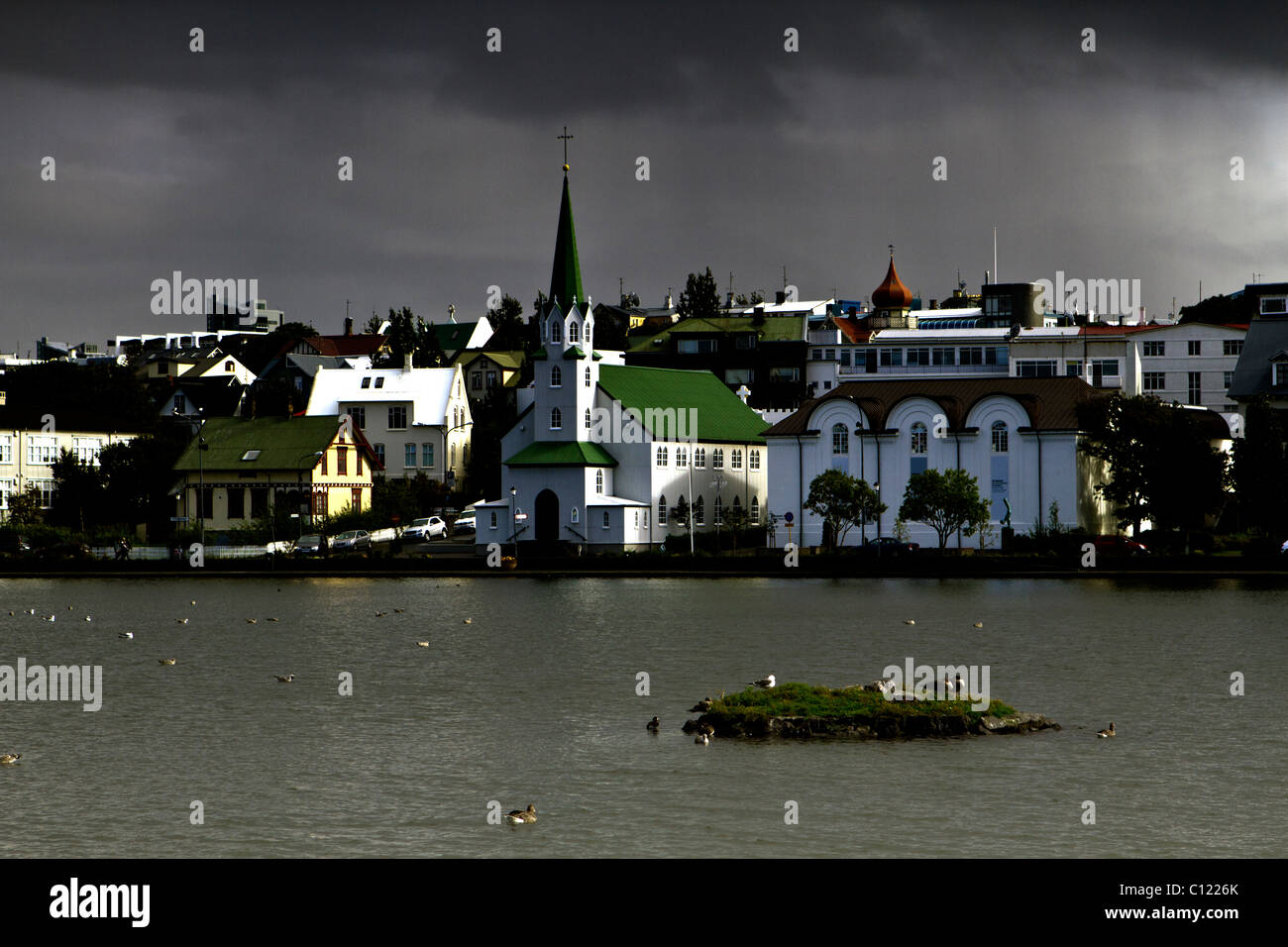 Fríkirkjan, la libera Chiesa luterana sulla banca del lago Tjörnin, o lo stagno, Reykjavik, Islanda Foto Stock