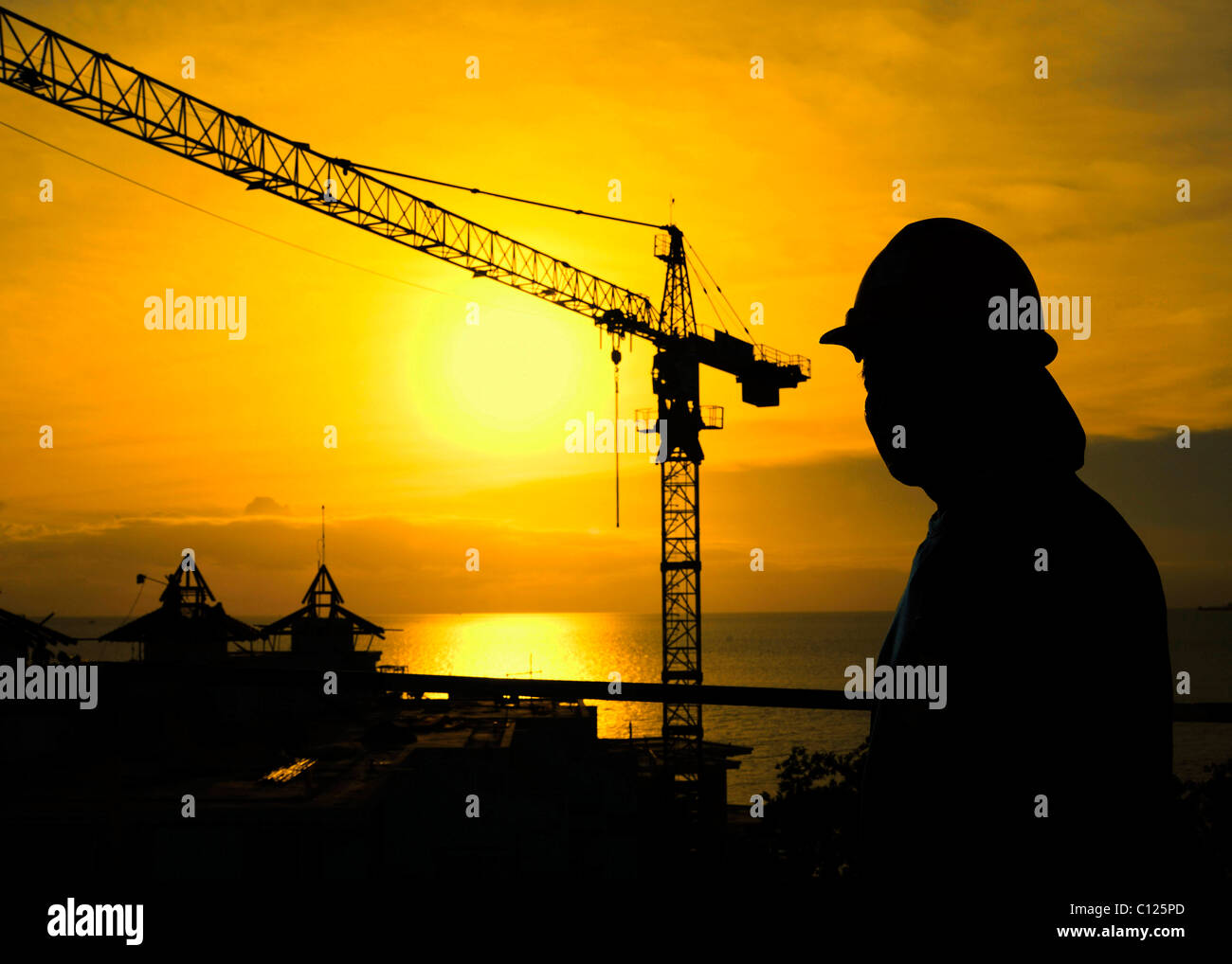 Gru da cantiere e lavoratore edile al tramonto, Thailandia, Asia Foto Stock
