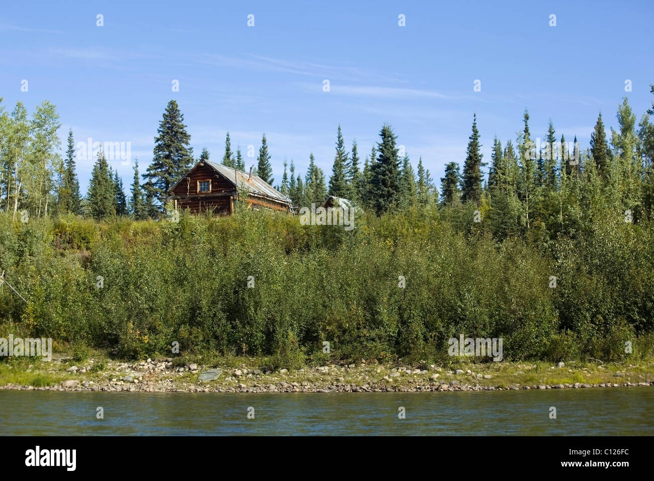 Vecchia cabina di intrappolamento, log cabin, fino sulla riva del fiume, superiore Liard River, Yukon Territory, Canada Foto Stock