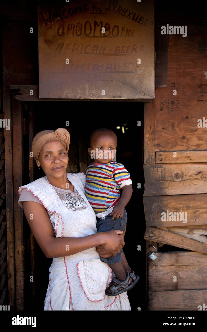 Donna con bambino di fronte a lei beer bar in Langa township, Cape Town, Western Cape, Sud Africa e Africa Foto Stock