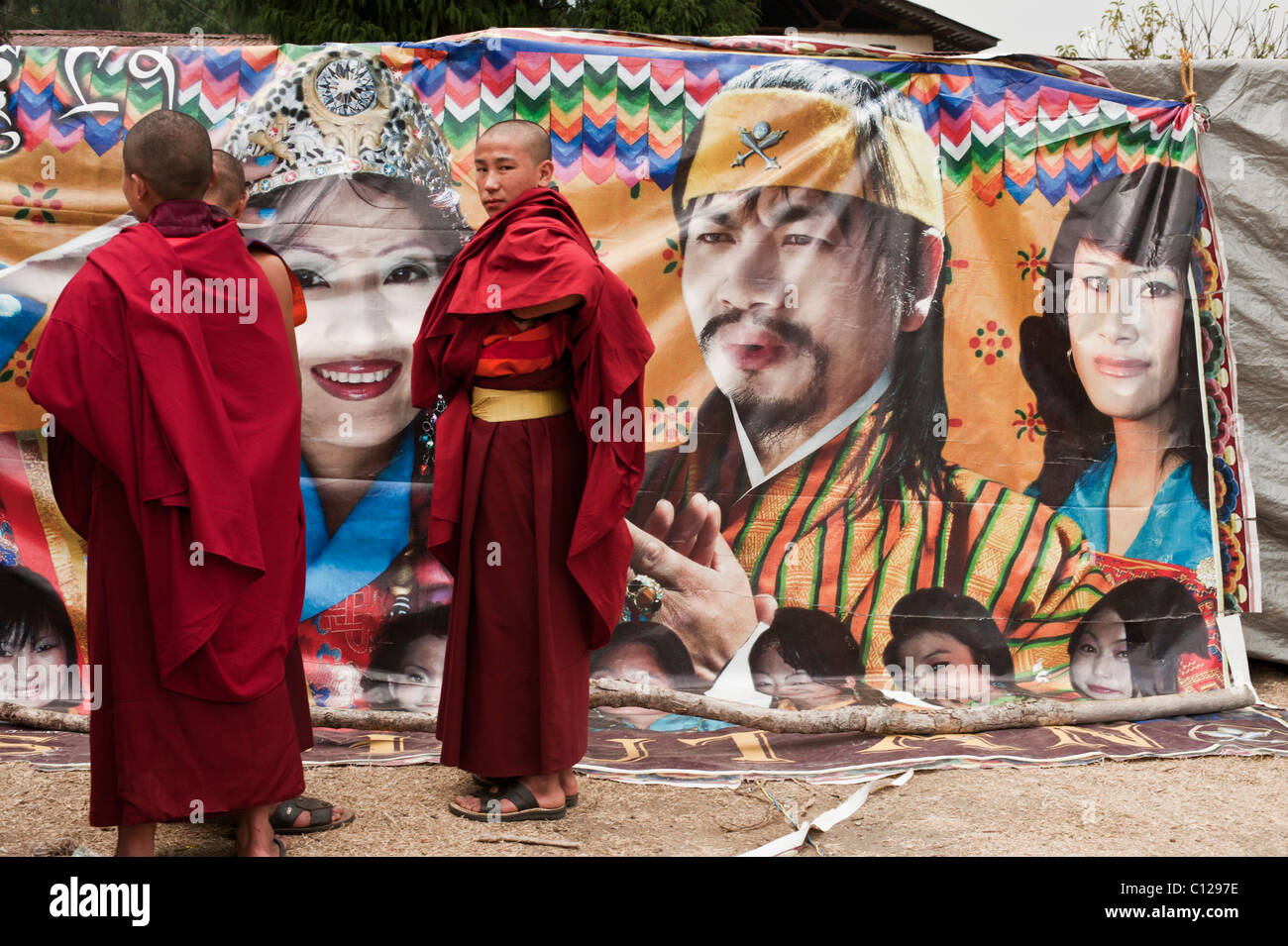 I monaci buddisti ponderare le virtù di comprare un biglietto per una nuova pellicola essendo mostrata in una tenda in un festival nelle zone rurali del Bhutan. Foto Stock