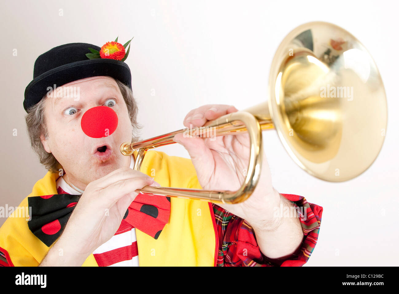 Clown con una fanfara tromba, naturali o a campana clarion Foto Stock