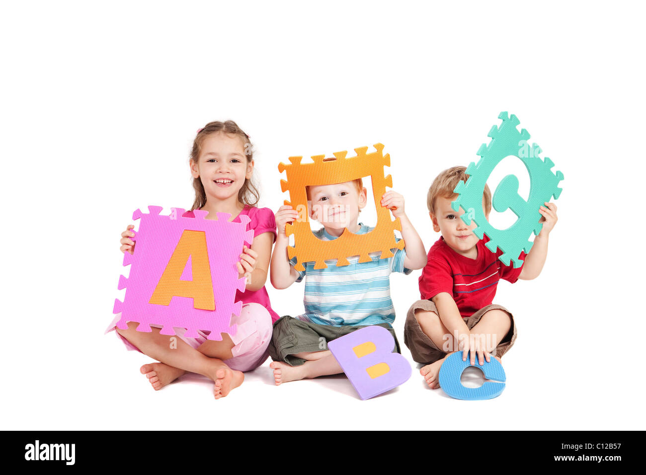 Tre bambini divertirsi imparando con alfabeto lettere ABC. Foto Stock