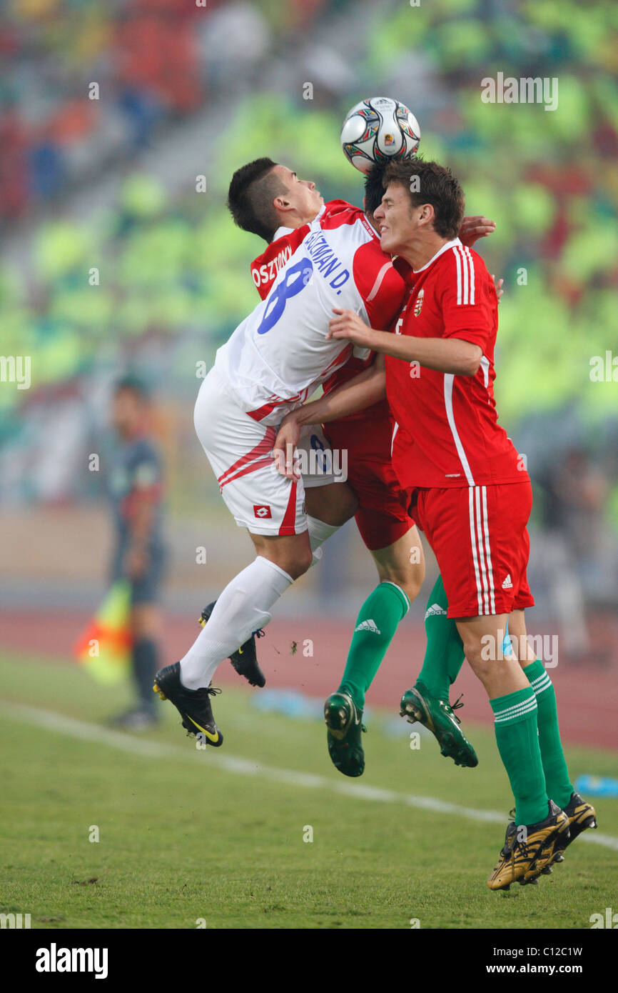 David Guzman della Costa Rica (C) è schiacciato dai giocatori ungheresi Andras Gosztonyi (L) e Zsolt Korcsmar (R) mentre combatte per un colpo di testa durante la partita del terzo posto della Coppa del mondo FIFA U-20 2009 allo Stadio Internazionale del Cairo, 16 ottobre 2009, al Cairo, in Egitto. Solo per uso editoriale. Uso commerciale vietato. (Fotografia di Jonathan Paul Larsen / Diadem Images) Foto Stock