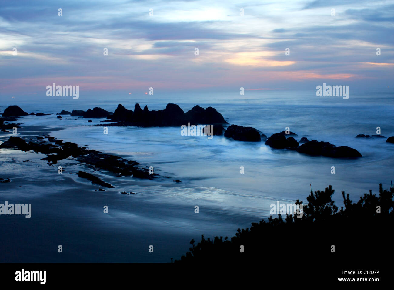 40,150.05789un morbido giallo blu Rosa tramonto riflessioni, uccelli marini, gabbiani uccelli onde da surf breakers beach tide balze rocciose tumuli isole di pile di mare Foto Stock