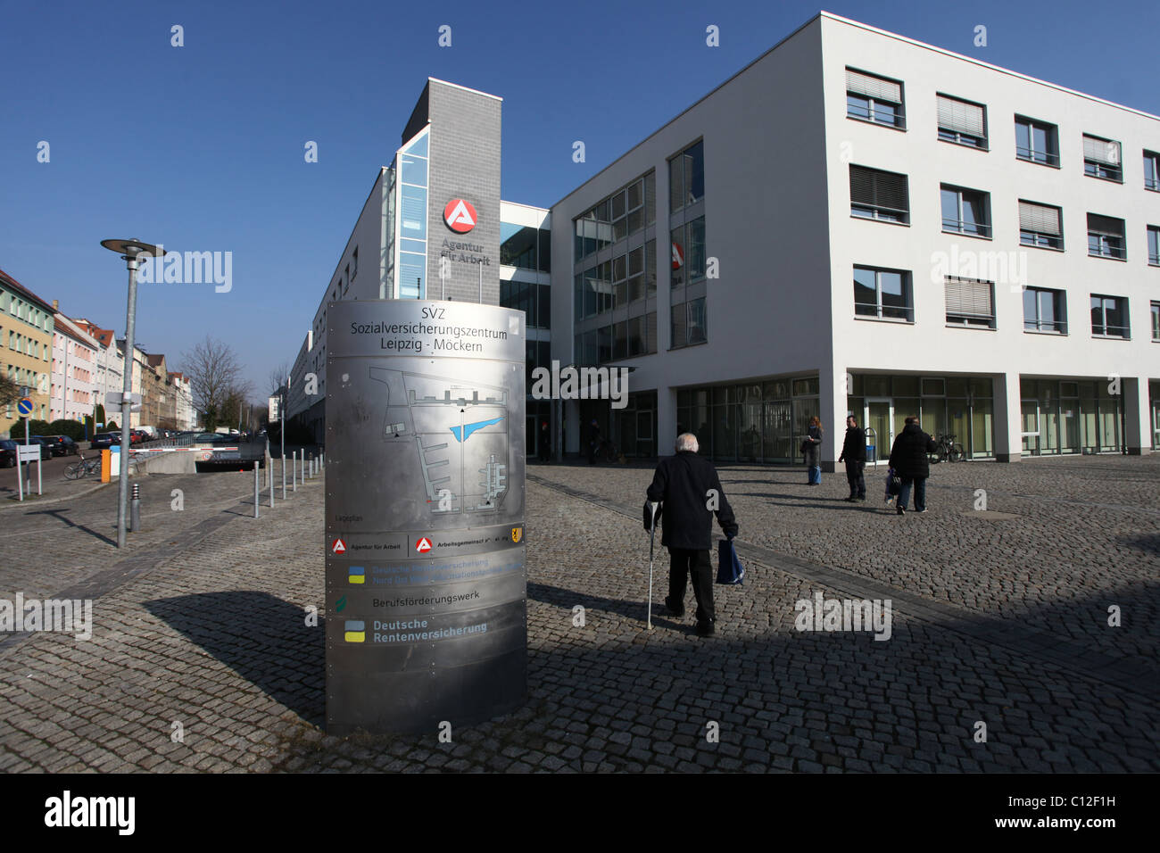I pedoni passano davanti all'Agenzia per il lavoro Agentur für Arbeit Leipzig nello Stato di Lipsia, in Sassonia, in Germania, l'Agentur für Arbeit è un'agenzia federale tedesca sotto il Ministero federale del lavoro e degli affari sociali che fornisce servizi per il mercato del lavoro, tra cui collocamento e consulenza professionale, e amministra le indennità di disoccupazione. Foto Stock
