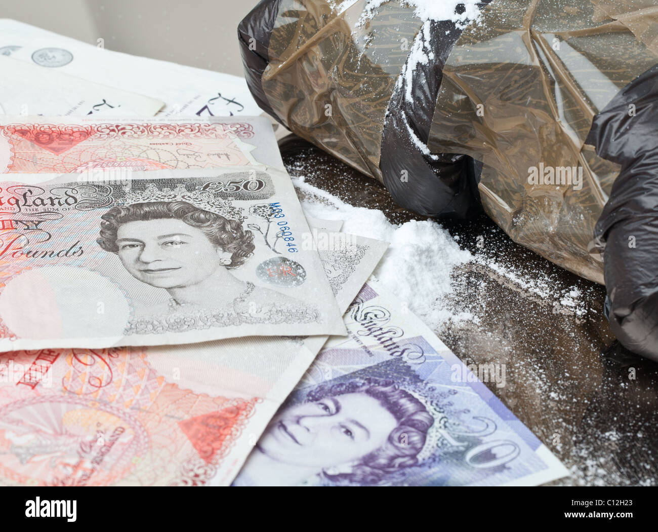 Confezioni di cocaina su uno specchio insieme con la valuta britannica Foto Stock