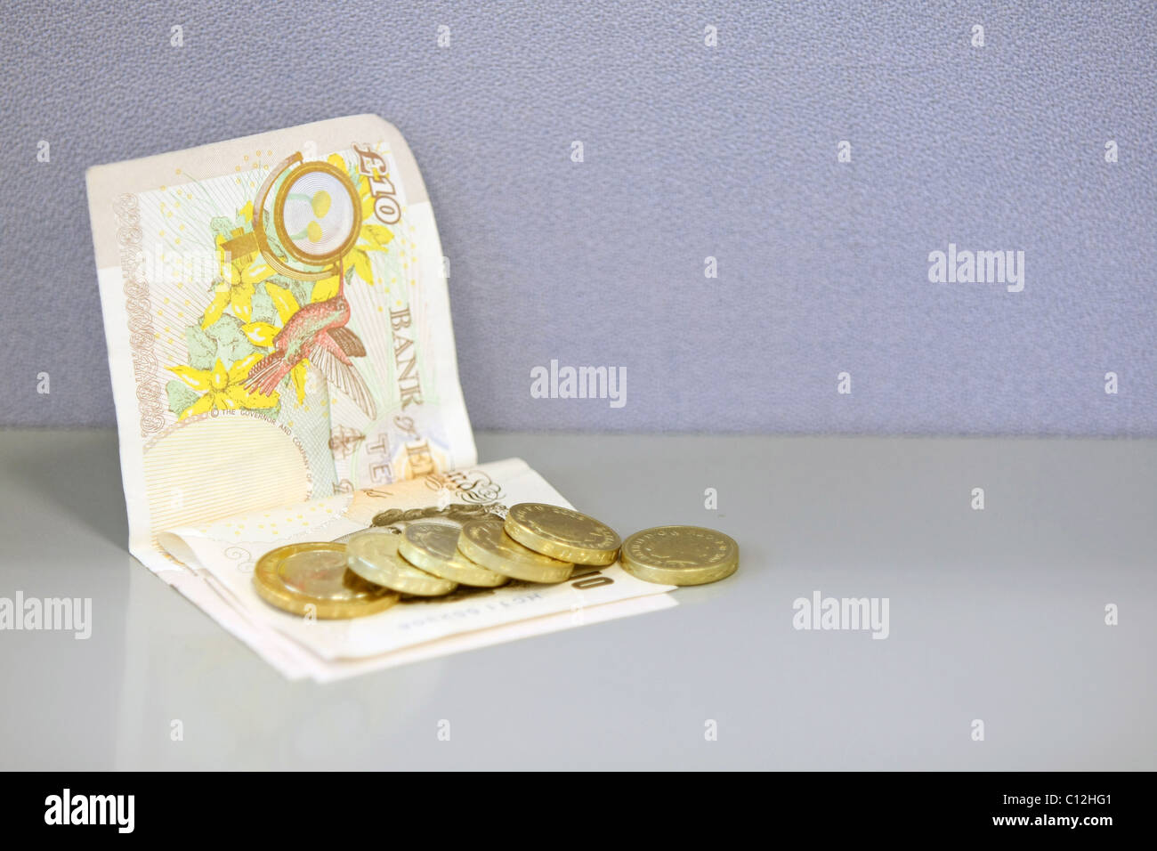 Una sterlina GBP 2 monete e alcuni £1 monete su £10 note Foto Stock