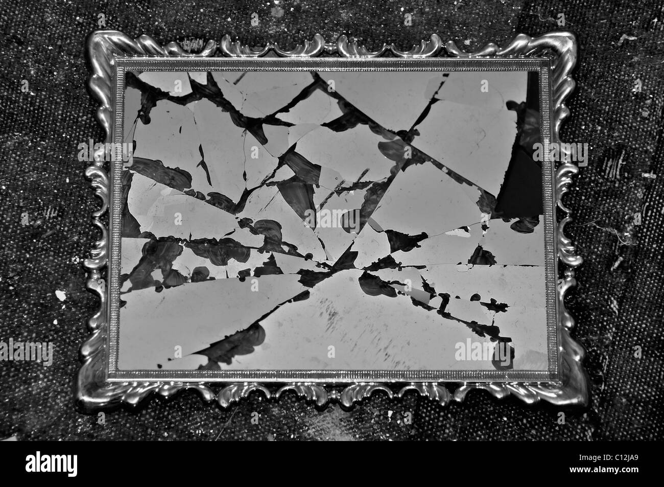 Antique Picture Frame con il vetro rotto su dirty rag sfondo. In bianco e nero. Foto Stock