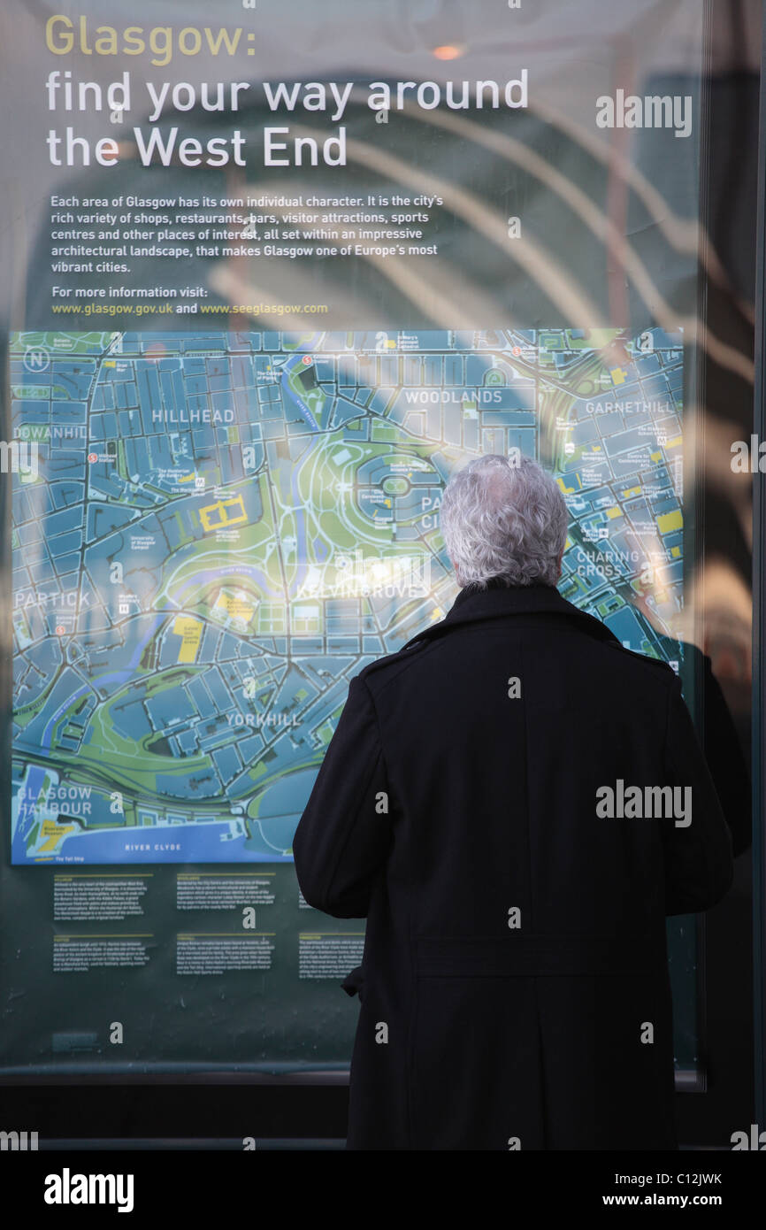 Un uomo che guarda una mappa stradale pubblica di Glasgow nel West End, Scozia, Regno Unito Foto Stock