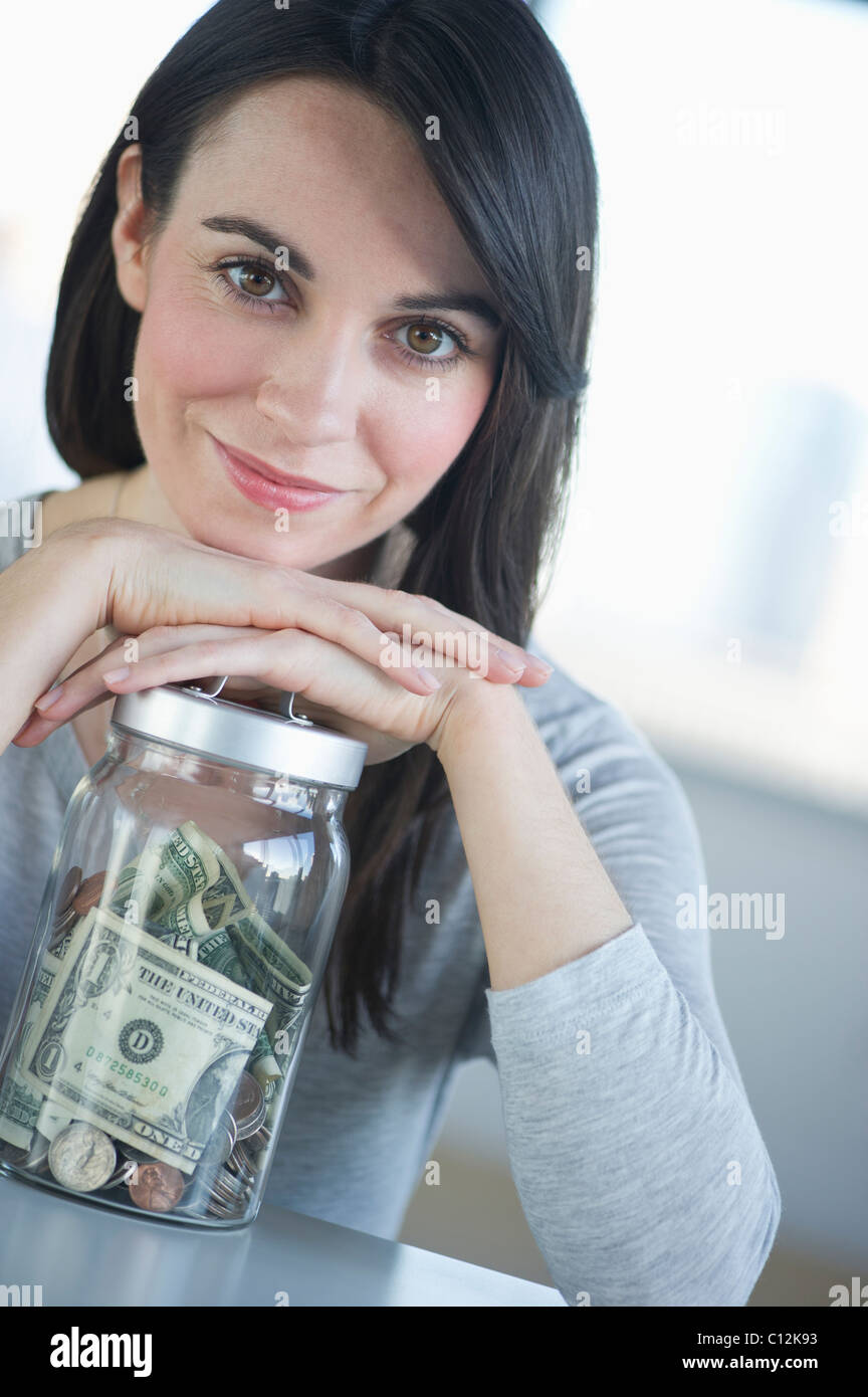 Stati Uniti d'America, New Jersey, Jersey City, Ritratto di giovane donna sorridente con risparmi in vaso Foto Stock