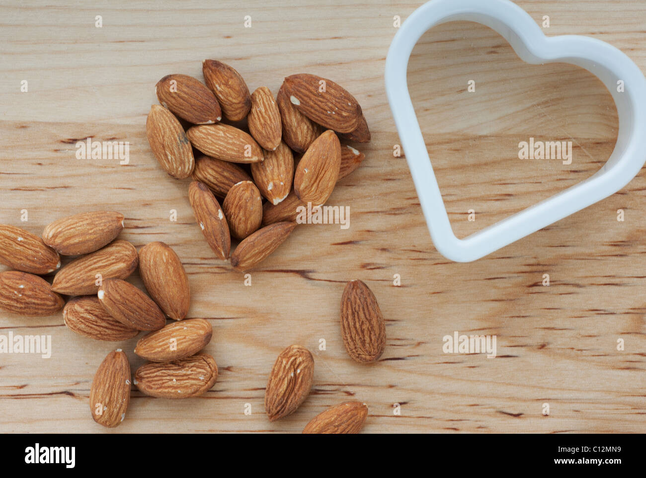 A forma di cuore le mandorle con fresa sul tagliere Foto Stock