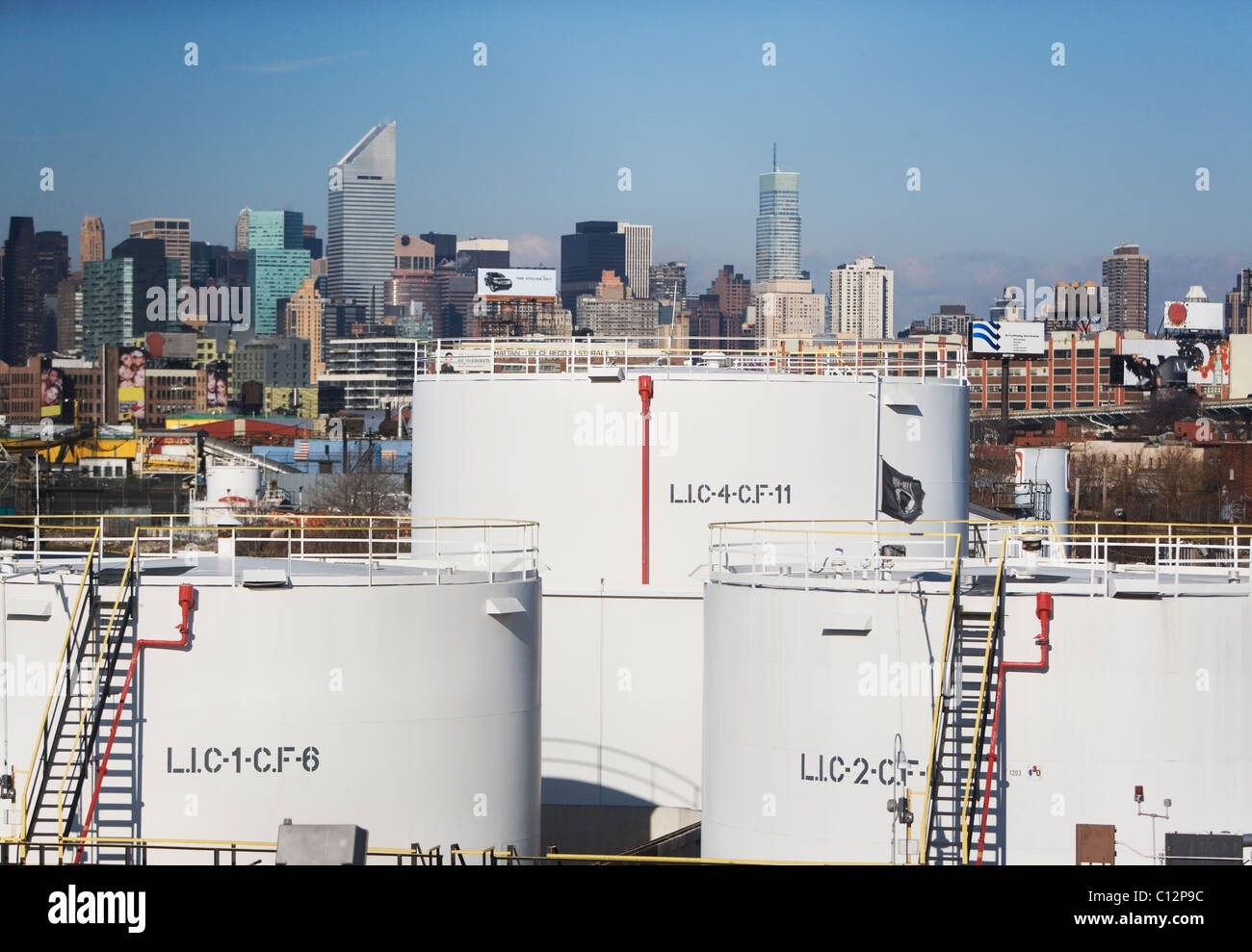 Stati Uniti d'America, New York City, olio serbatoi di stoccaggio in raffineria con lo skyline di Manhattan in background Foto Stock