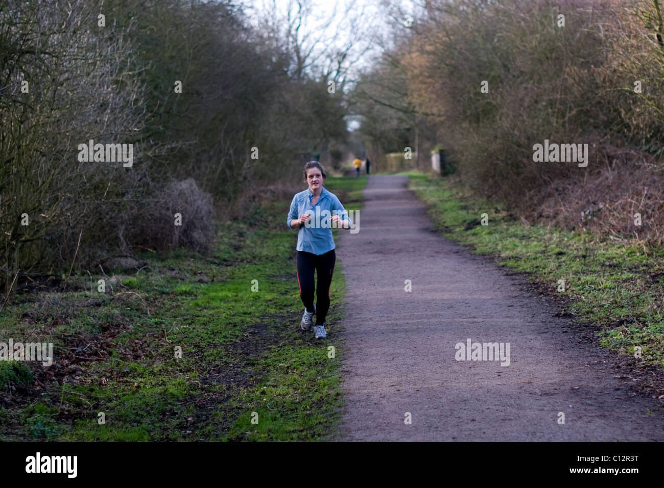 Giovane donna in esecuzione sul sentiero a Kenilworth, Warwickshire. Foto Stock