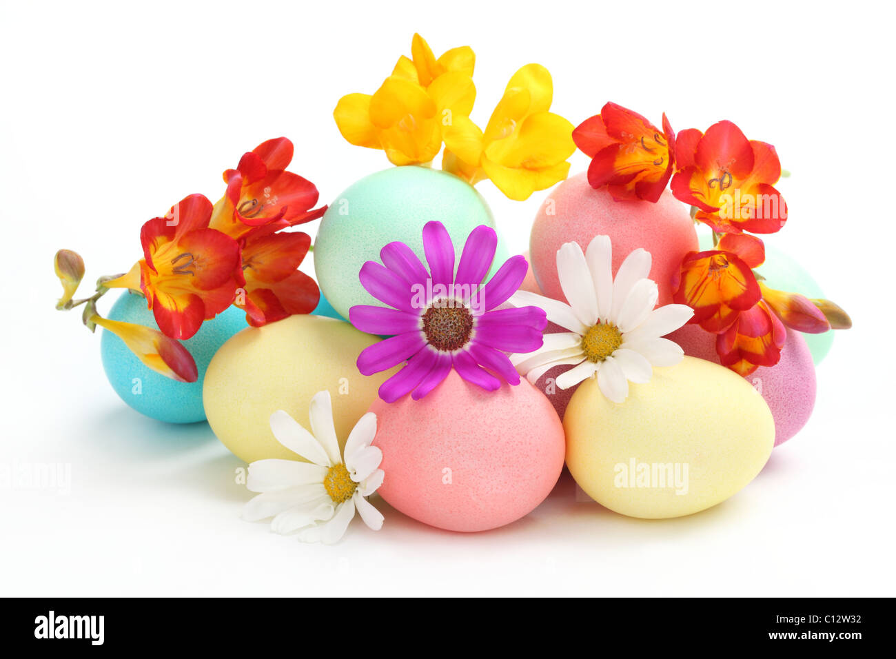 Colorate le uova di pasqua con fiori di primavera su sfondo bianco Foto Stock