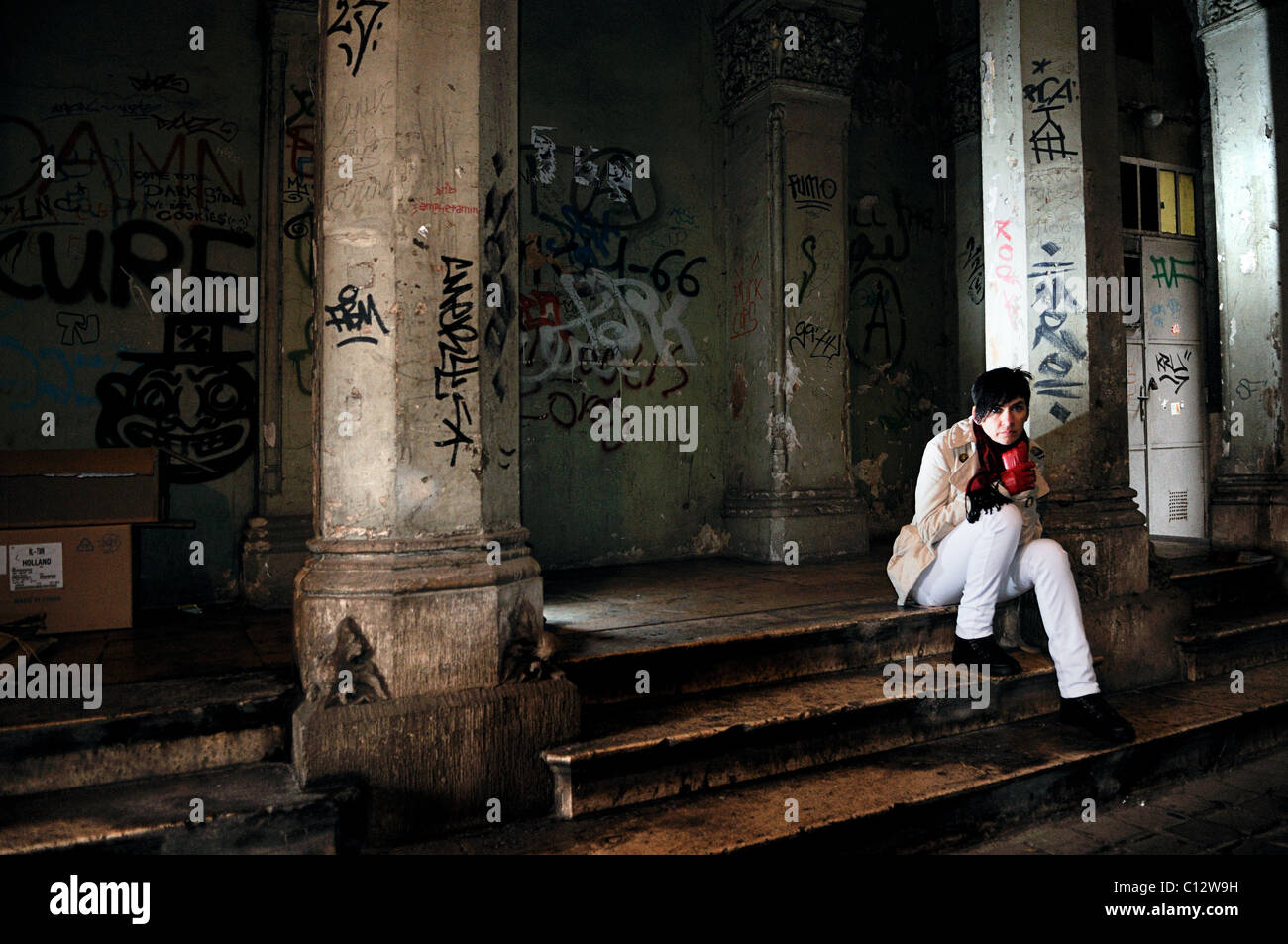 La donna si siede sul soggetto ad atti vandalici fasi di costruzione esterno, Ungheria, Budapest Foto Stock
