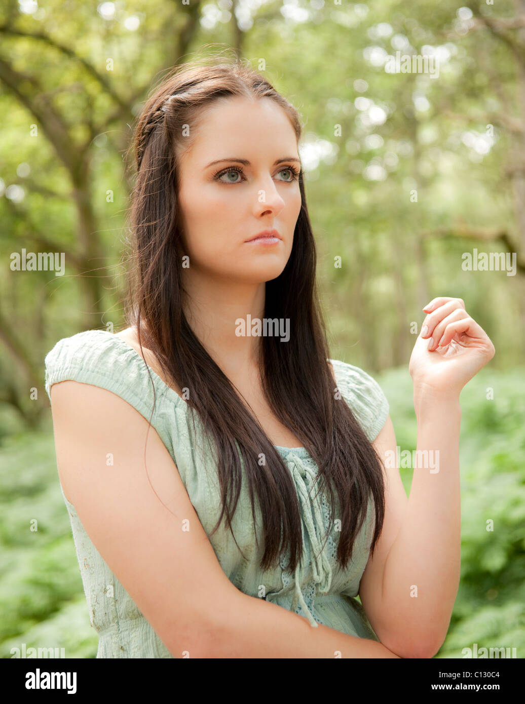 Ritratto di giovane donna in piedi in una foresta Foto Stock