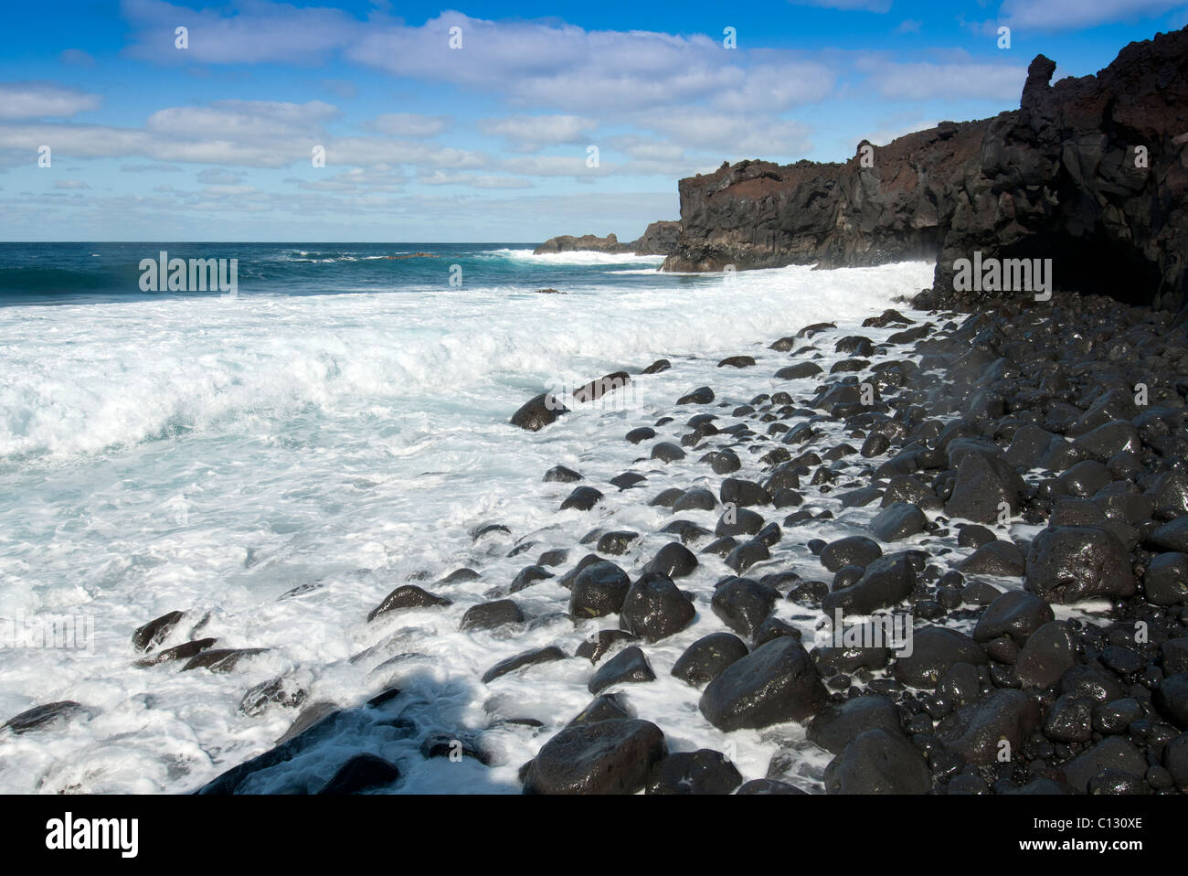 Nere rocce laviche , onde del mare Lanzarote Foto Stock