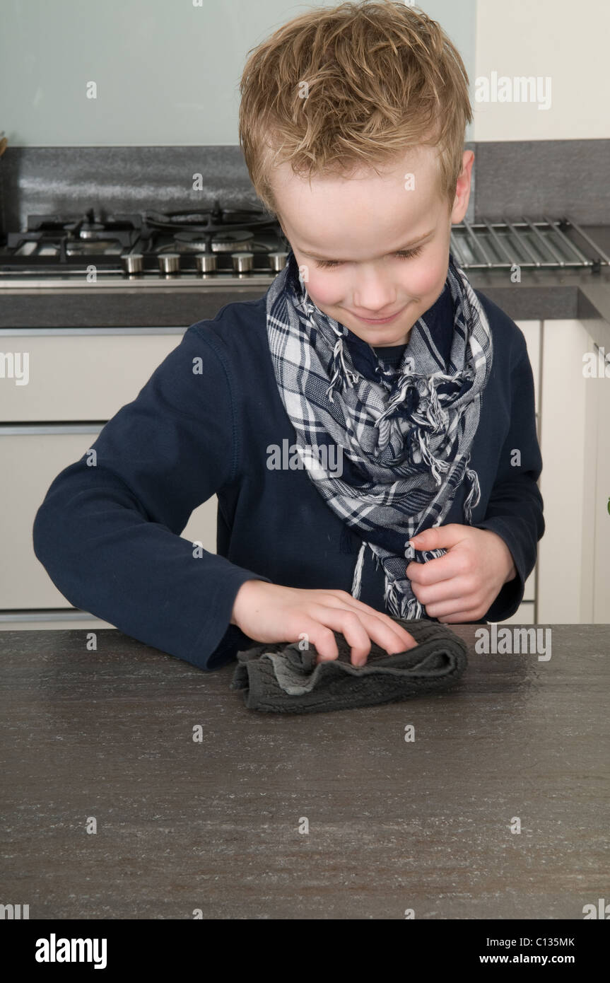 Ragazzo la pulizia della cucina dopo aver qualcosa da mangiare. Foto Stock