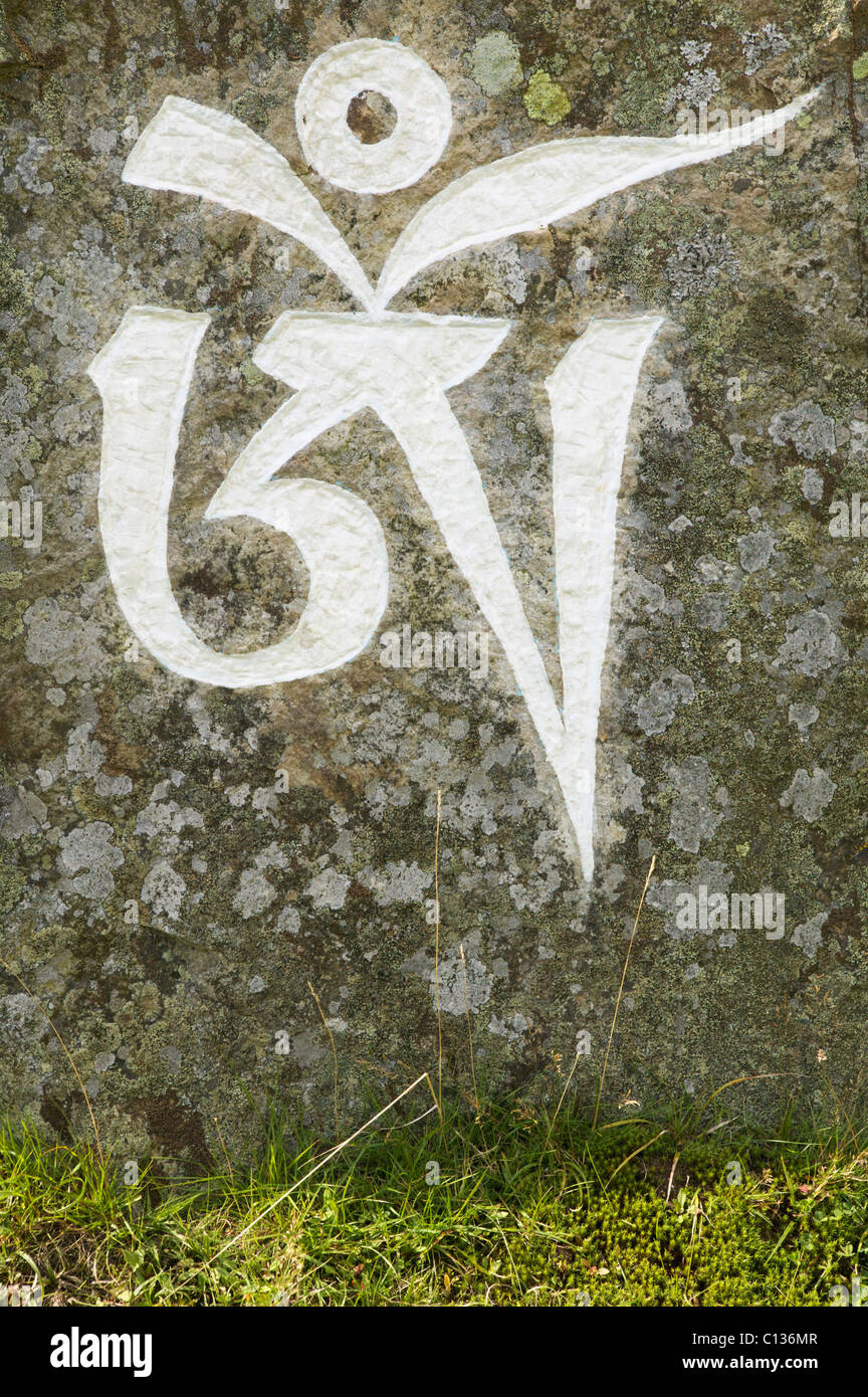 Il primo simbolo del mantra buddista, OM MANI PADME HUM, scritta su una pietra, Isola Santa, Isle of Arran, Scotland, Regno Unito. Foto Stock