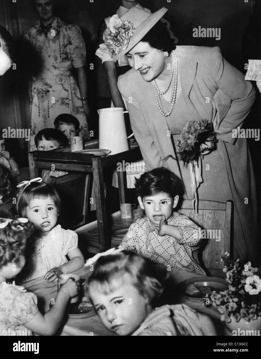 Queen Elizabeth (indietro a destra), l'ex duchessa di York, visitando un vivaio, circa 1943. Foto Stock