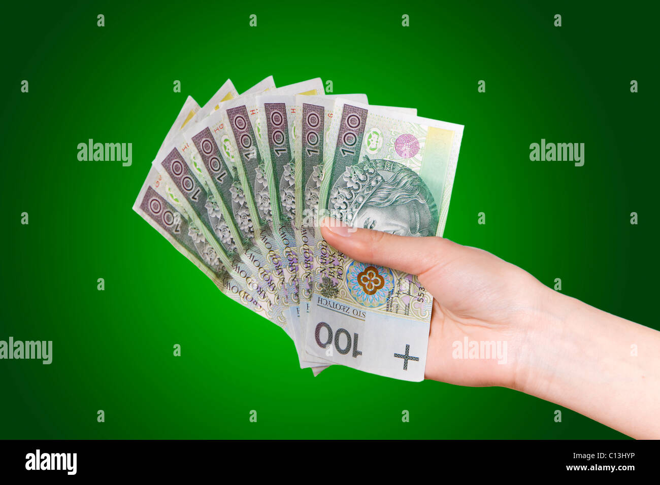 La mano con il polacco soldi su sfondo verde Foto Stock