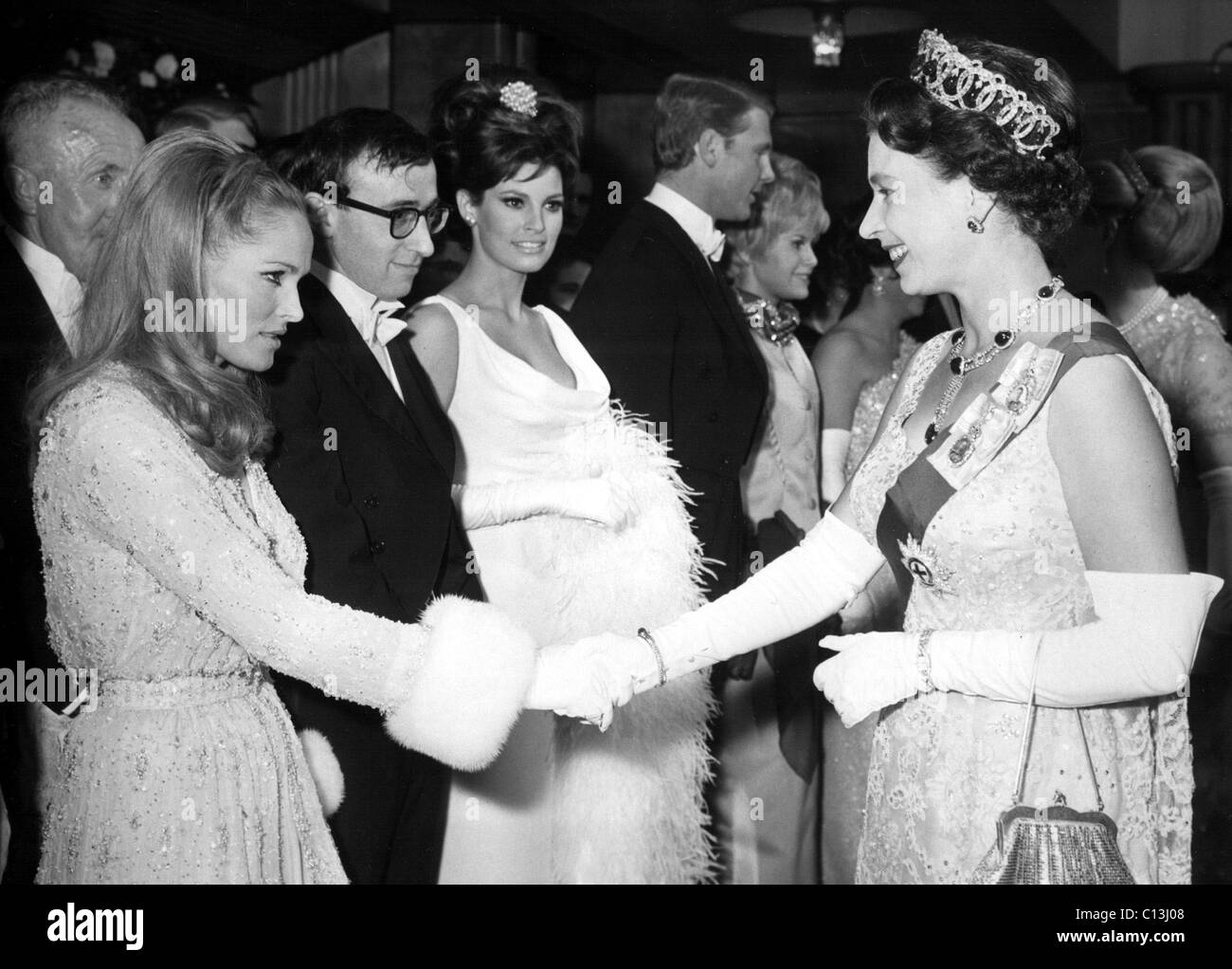Ursula Andress, Woody Allen, Raquel Welch essendo accolti dalla Regina Elisabetta II presso il Royal Film Performance di nati gratuitamente presso il Foto Stock