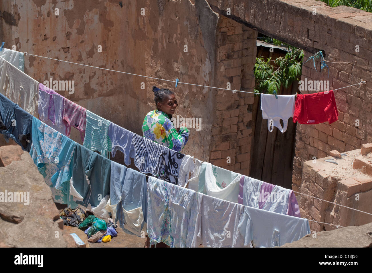 La donna e la linea di lavaggio in ambiente urbano back yard. Antanananarivo. Madagascar Foto Stock