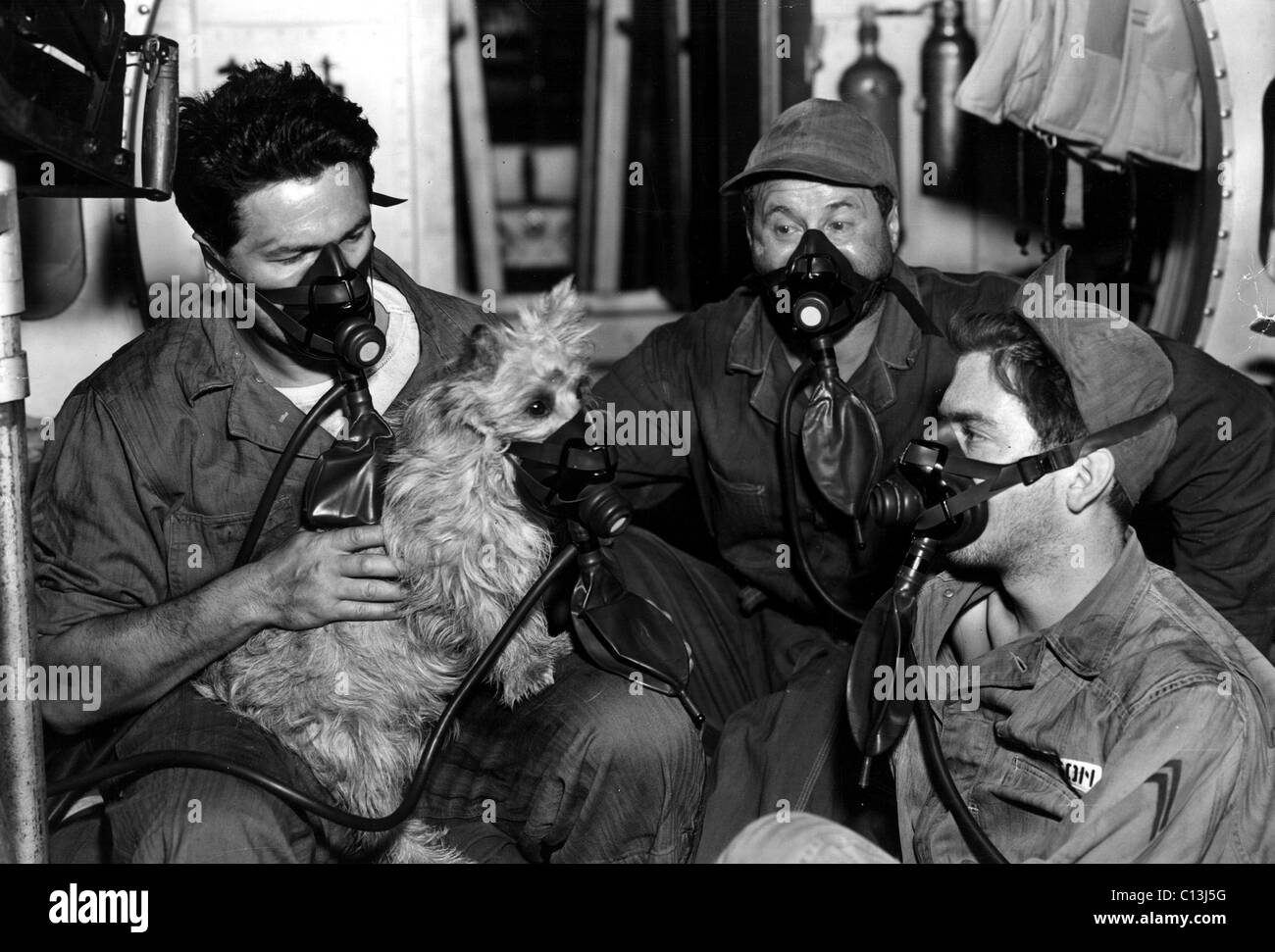 JOHN GARFIELD, GEORGE TOBIAS e WARD legno controllare per vedere se il compagno di membro del cast del ROMMIE maschera a gas si inserisce durante la produzione della AIR FORCE, 1943 Foto Stock