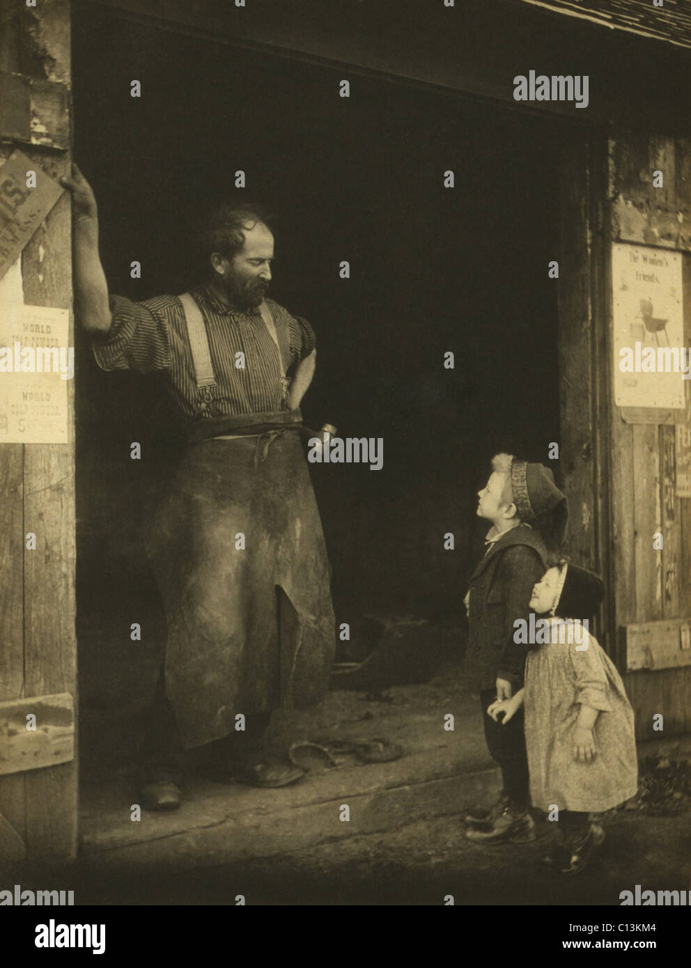 Un cuoio aproned fabbro nella porta della sua fucina di parlare per due ragazzi. Fotografia di Francesca Stebbins Allen, c. 1900. Foto Stock