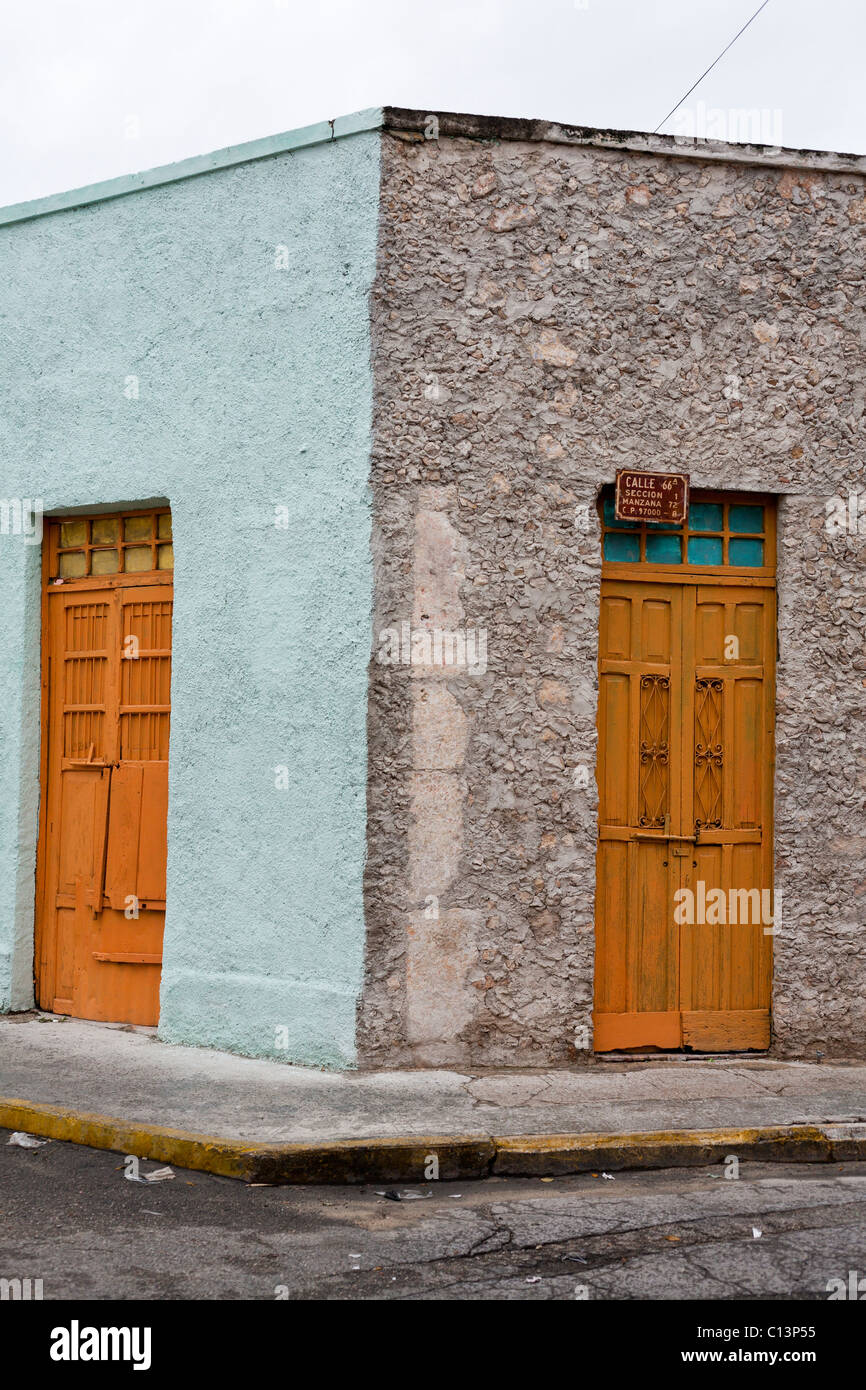 Angolo di strada in Merida con porte arancione: Calle 66a. Due circa il dipinto di vecchie porte su un angolo di strada con un po' di spazzatura Foto Stock