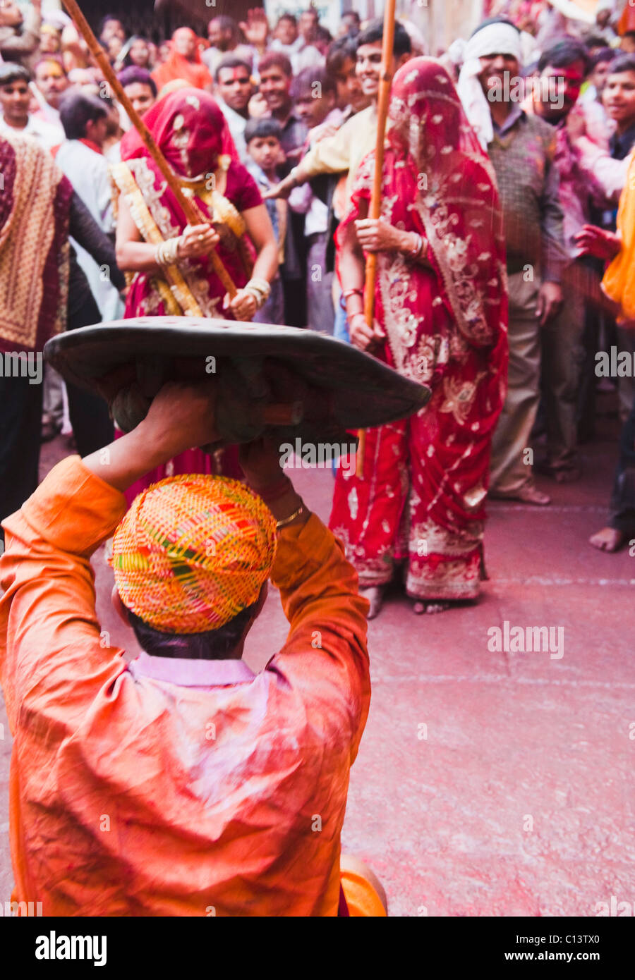 La gente celebra "listello Maar Holi festival", Barsana, Uttar Pradesh, India Foto Stock