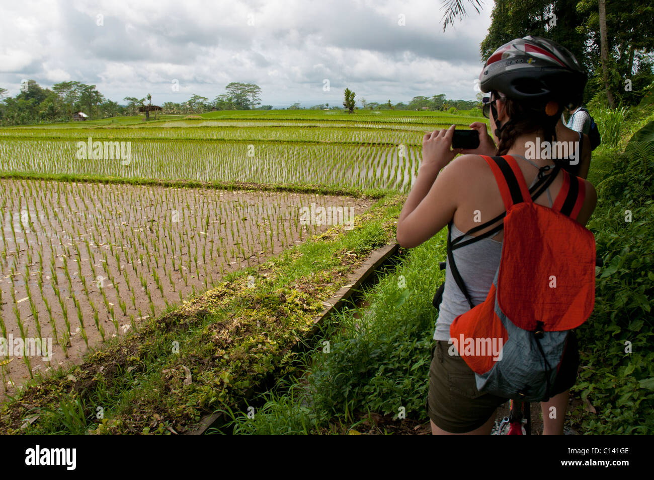 In mountain bike attraverso i villaggi e le risaie di Bali Indonesia Foto Stock