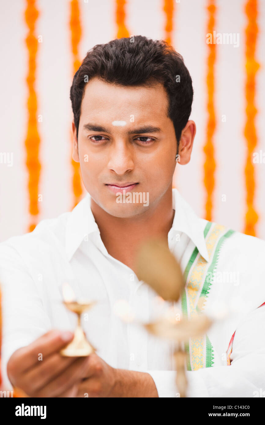 Sposo pregando nel sud tradizionale abito indiano Foto Stock