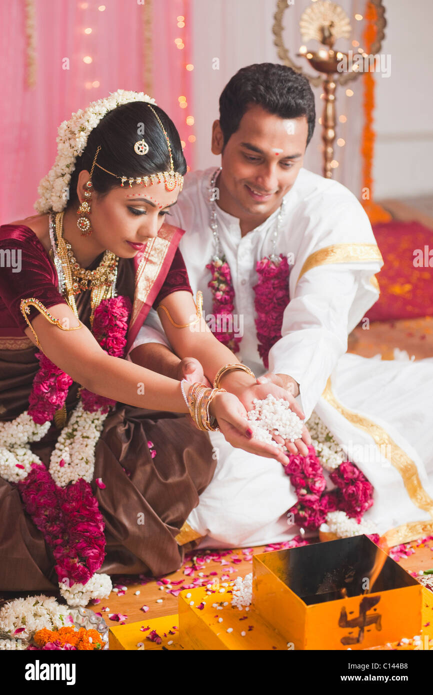 Sposa e lo sposo di eseguire una cerimonia religiosa durante il sud indiane matrimonio Foto Stock