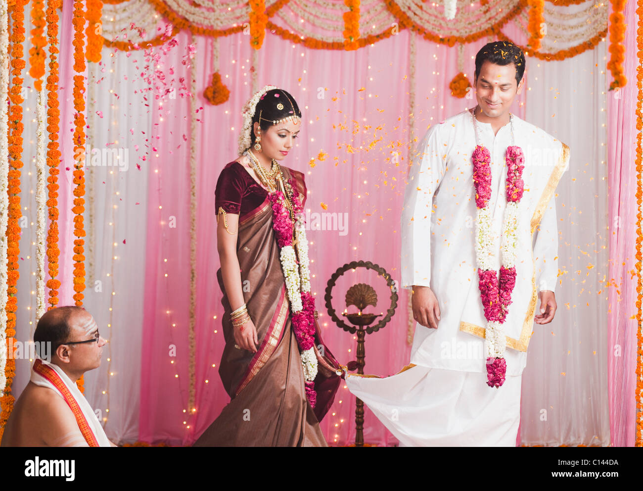 Sposa e lo sposo tenendo Saptha Padhi durante il sud indiane matrimonio Foto Stock