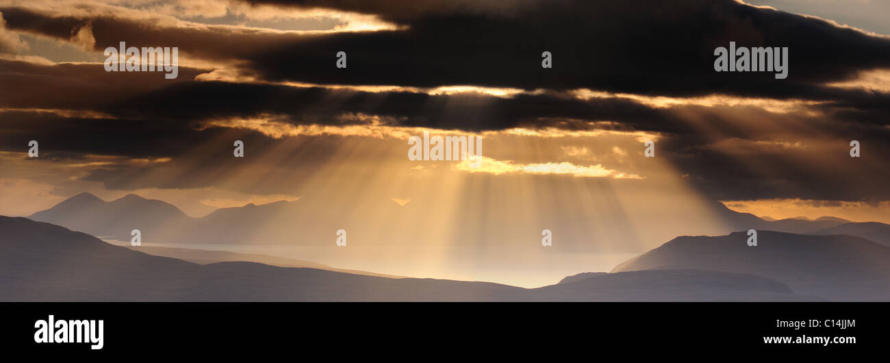 Raggi crepuscolari dal vertice di Tom na Gruagaich su Beinn Alligin guardando verso l'Isola di Skye e le montagne Cuillin Foto Stock