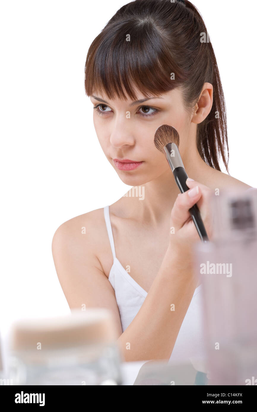 Cura del corpo: giovane donna l'applicazione di polvere con il make-up pennello su sfondo bianco Foto Stock