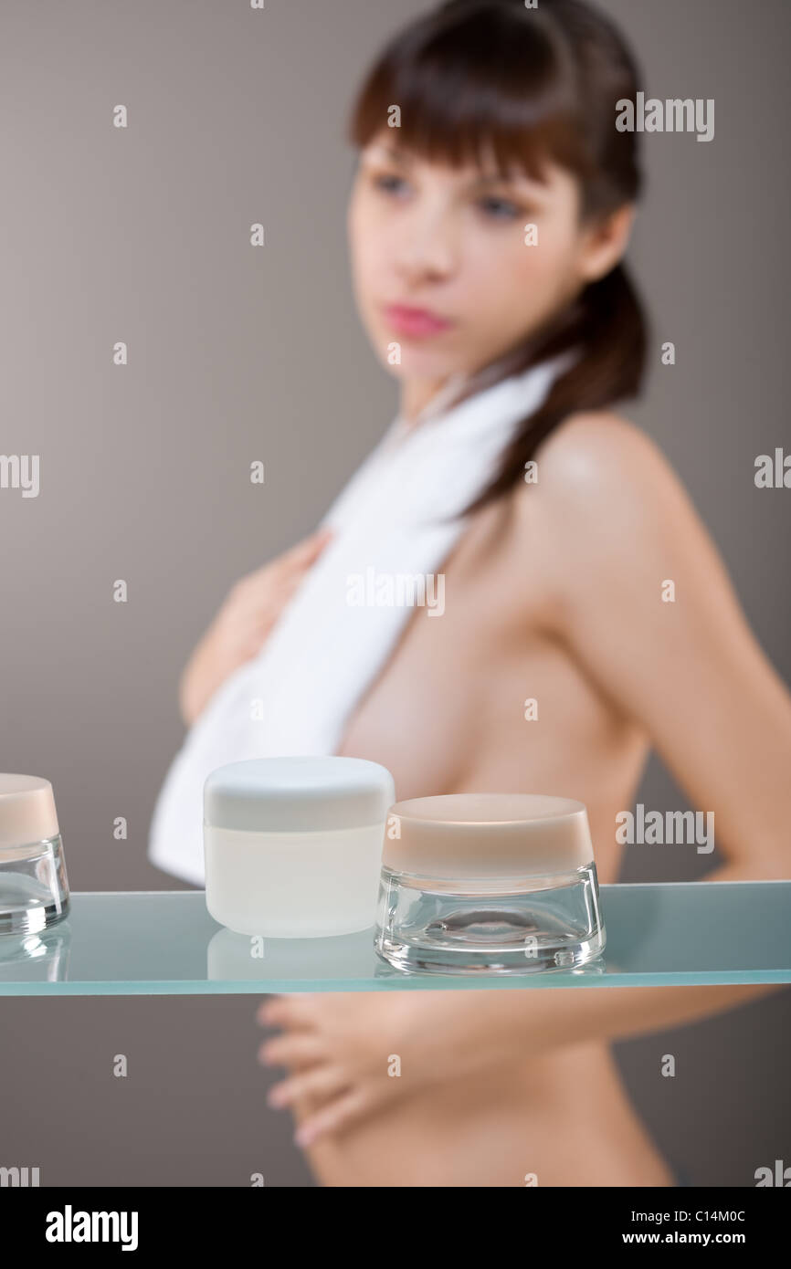 Cura del corpo: giovane donna in bagno, concentrarsi sul vasetto di crema Foto Stock