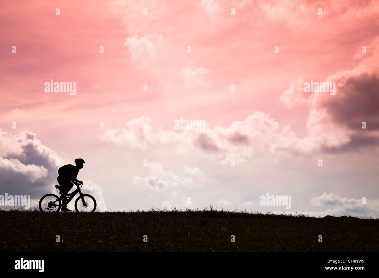 La Silhouette di mountain bike rider e al tramonto Foto Stock