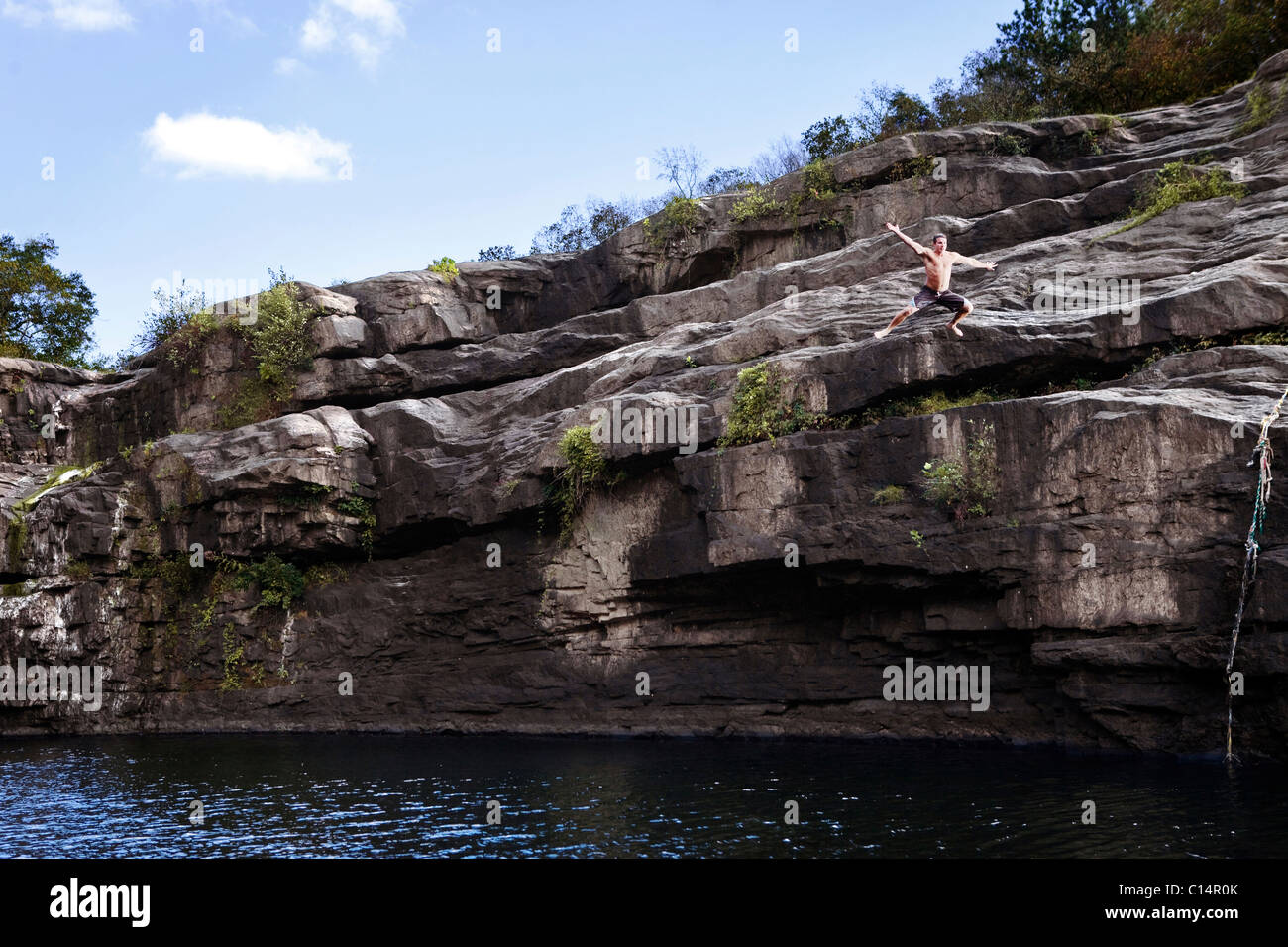 Giovane uomo cade dalla scogliera di roccia in una laguna ad alta Falls Park, Geraldine, Alabama. Foto Stock