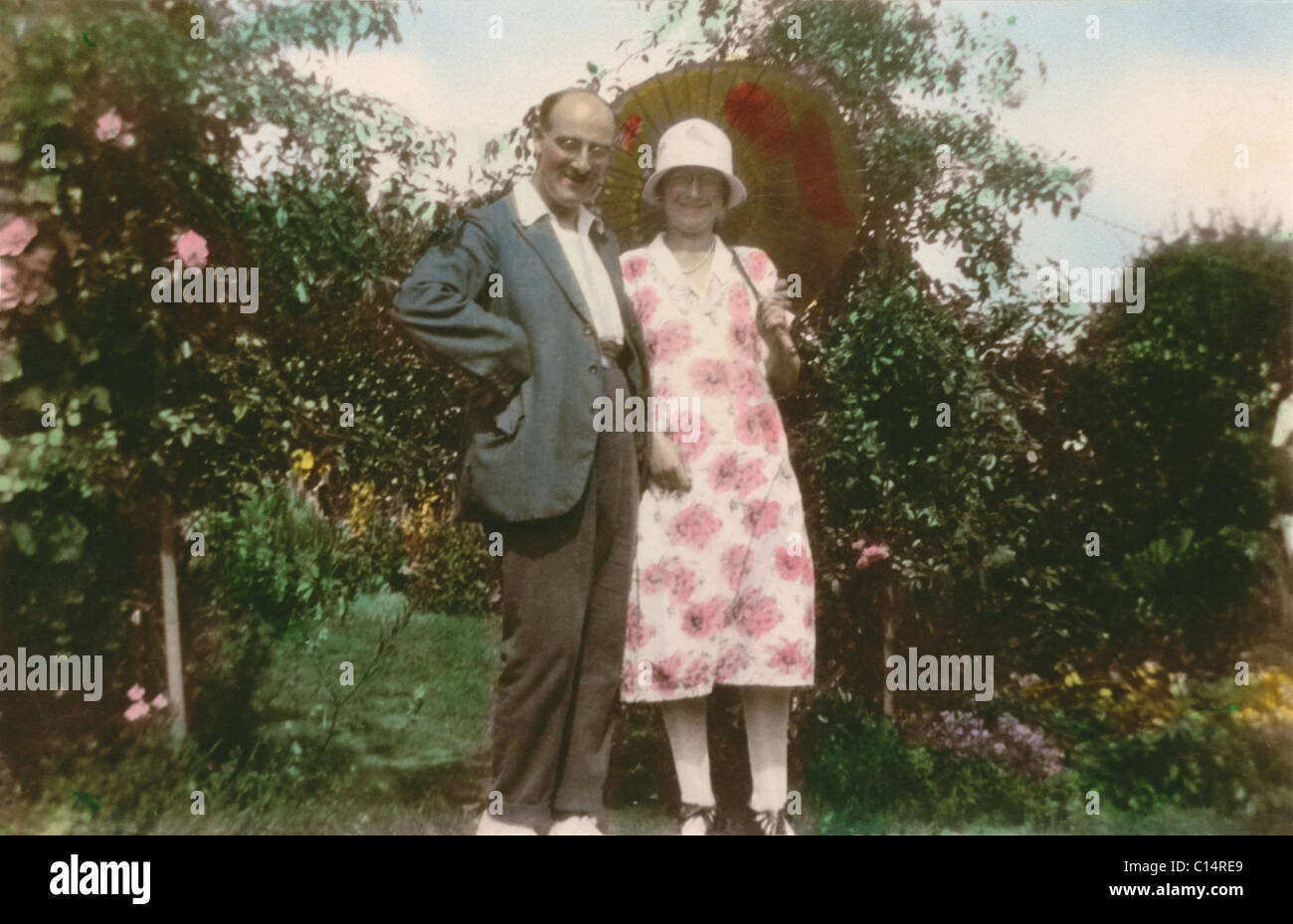 Fotografia oscurata del giovane nel giardino soleggiato, la signora indossa una cloche hat ,circa 1928, ventenne 20's U.K. Foto Stock