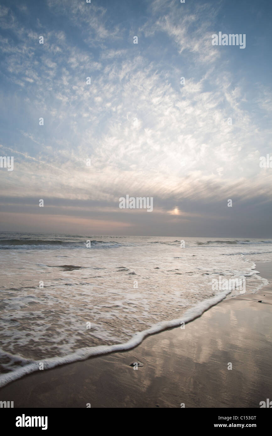 Il tramonto e le onde su una spiaggia in Galles del Nord Foto Stock