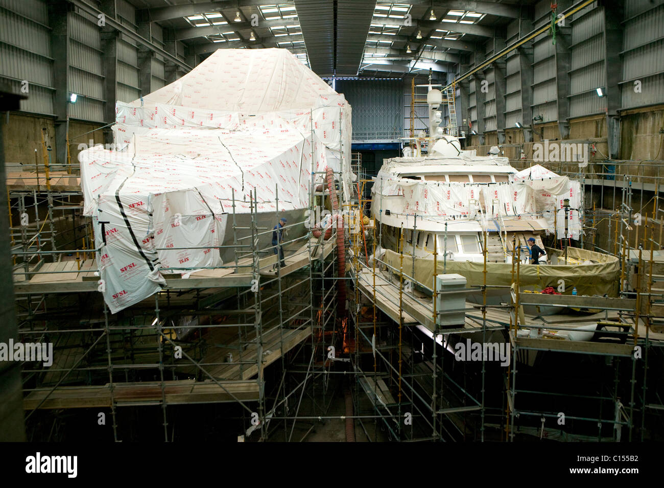 Barche sotto avvolge a Pendennis Shipyard, Falmouth, Regno Unito. Foto Stock