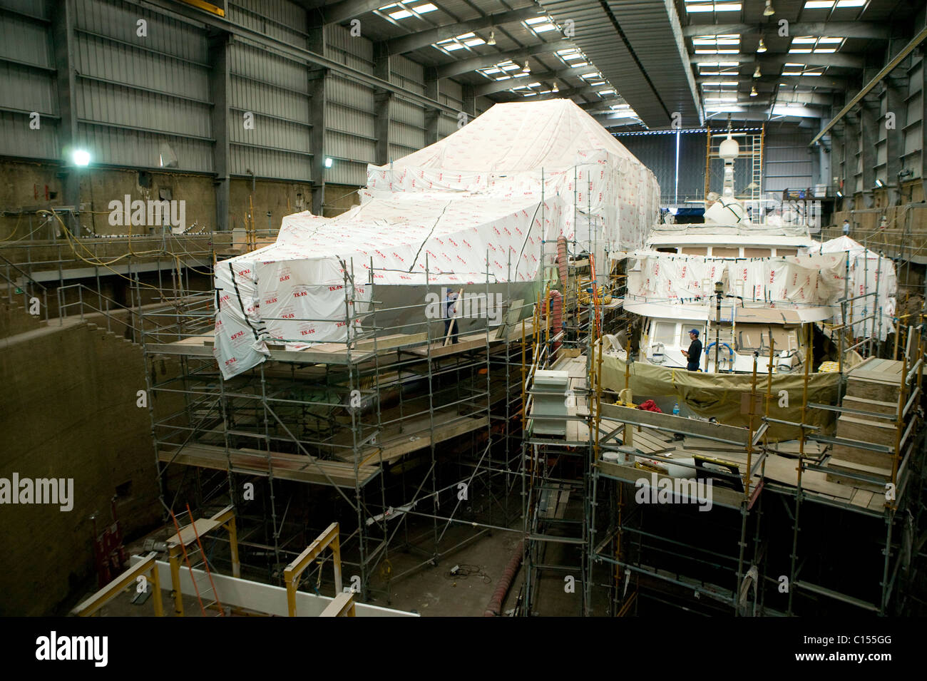 Barche sotto avvolge a Pendennis Shipyard, Falmouth, Regno Unito. Foto Stock