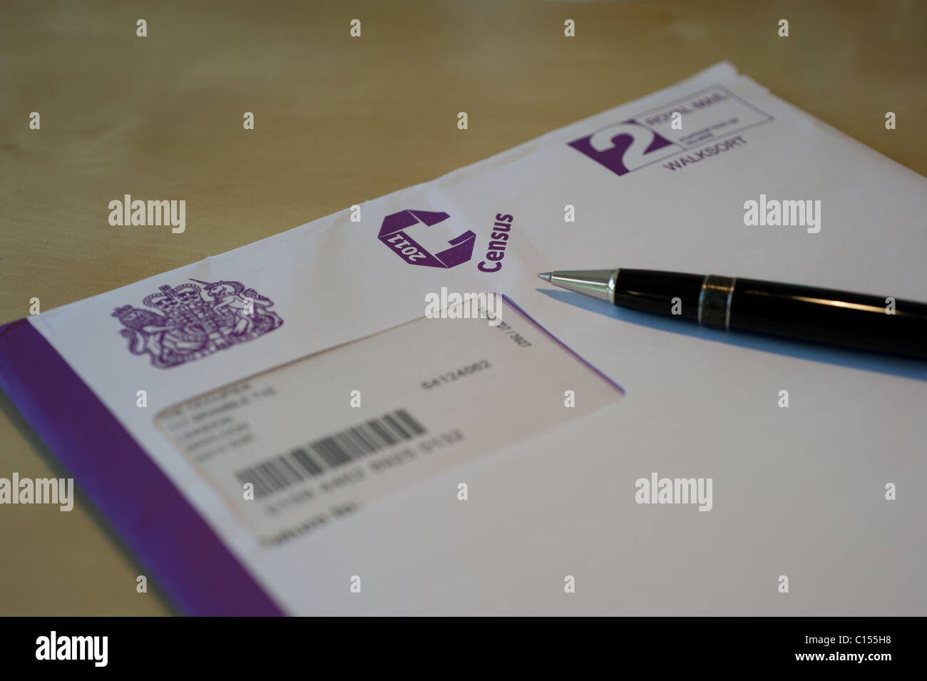 Un aperti 2011 Regno Unito questionario di censimento seduto sulla scrivania con la penna. Messa a fuoco differenziale di oscurare i dettagli personali. Foto Stock