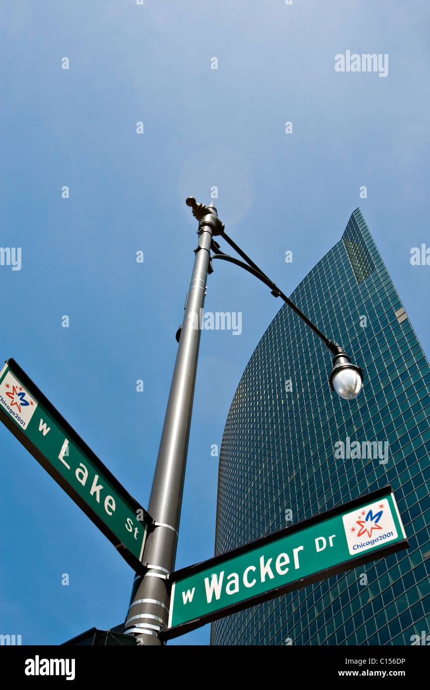 Lampione con indicazioni stradali nella parte anteriore del grattacielo a basso angolo di visione Foto Stock