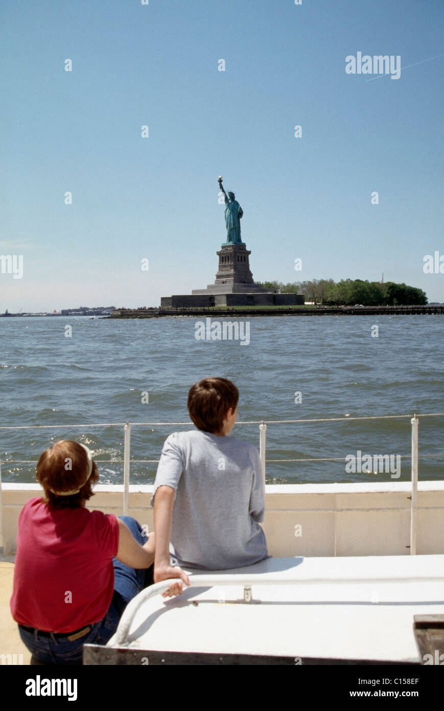 Due persone in barca, guardando la Statua della Libertà Foto Stock