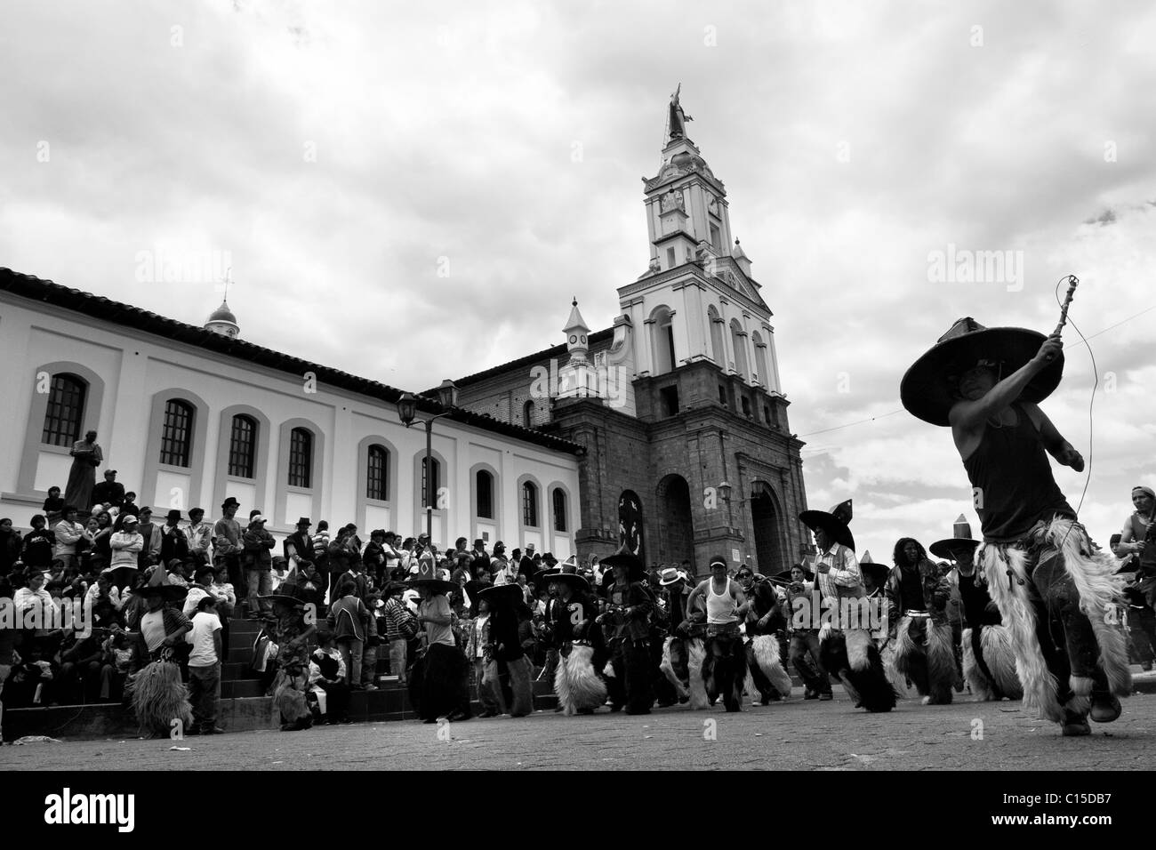 Gli indiani, indossa una pelle di capra chaps, danza furiosamente durante l'Inti Raymi (san juan) festeggiamenti di fronte alla Chiesa in Ecuador. Foto Stock