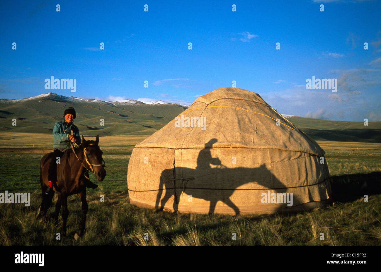 Cavallo e cavaliere di fronte una yurt, Moldo-Too Mountain Range, Song-Kul, Kirghizistan, Asia centrale Foto Stock